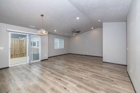 Tea townhouse for rent - A spacious room with wooden flooring and white walls.