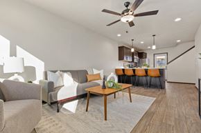 Brandon townhouse for rent - A living room with a grey couch, a wooden coffee table, and a ceiling fan.