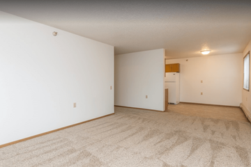 Sioux Falls apartment for rent - the living room and kitchen of an apartment with white walls and carpet