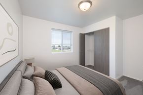 Sioux Falls apartment for rent - A bedroom with a large bed and a window overlooking a green area.