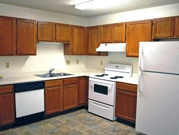 Sioux Falls apartment for rent - a kitchen with white appliances and wooden cabinets