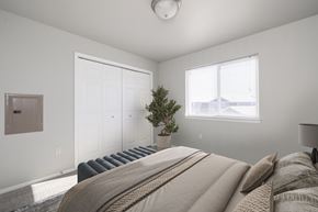 Sioux Falls apartment for rent - A bedroom with a large bed and a small tree in a pot.