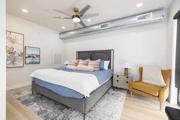 Sioux Falls apartment for rent - A bedroom with a bed, a chair, and a ceiling fan.