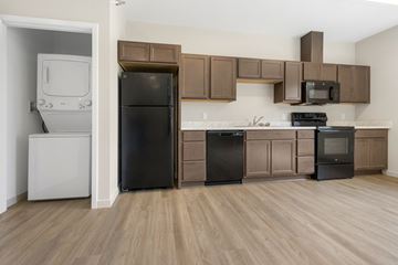 Sioux City apartment for rent - A kitchen with brown cabinets and black appliances.