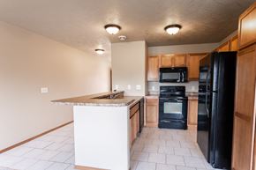Sioux Falls townhouse for rent - a kitchen with black appliances and a granite counter top