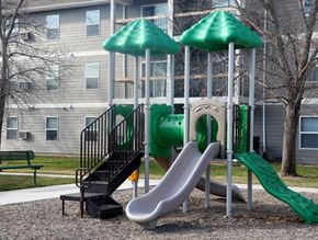 Sioux Falls townhouse for rent - a playground with a slide and two green umbrellas