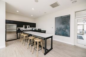 North Sioux City townhouse for rent - a kitchen with a long island with bar stools and a stainless steel refrigerator