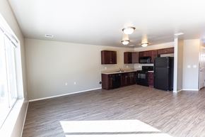 Sioux Falls townhouse for rent - a kitchen and living room with a wood floor and a black refrigerator