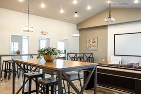 Sergeant Bluff townhouse for rent - a dining room with a table and chairs and a projection screen