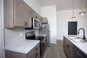 Sioux Falls apartment for rent - A kitchen with a white counter top and wooden cabinets.