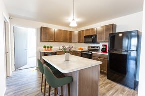 Harrisburg apartment for rent - A kitchen with a black refrigerator and a white island.