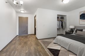 Sioux Falls townhouse for rent - A bedroom with a bed, a wardrobe, and a painting on the wall.
