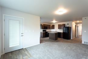 Sioux Falls apartment for rent - an empty living room and kitchen with a door open to a room with a kitchen