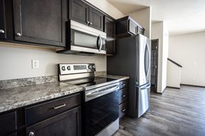 Sioux Falls townhouse for rent - a kitchen with black cabinets and stainless steel appliances
