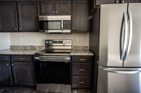 Sioux Falls townhouse for rent - a kitchen with stainless steel appliances and granite counter tops