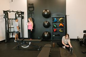 Des Moines apartment for rent - A woman is sitting on a mat in a gym, stretching her legs.