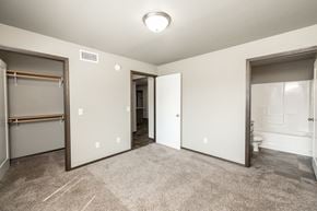 Sioux Falls townhouse for rent - a bedroom with a closet and a bathroom with a mirrored door