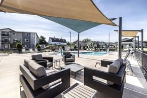 Sioux Falls townhouse for rent - A patio with black wicker furniture and a pool in the background.