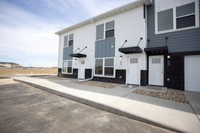 Sioux Falls apartment for rent - a white and black building with two white doors and a sidewalk