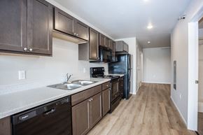 Sioux Falls apartment for rent - a kitchen with dark wood cabinets and stainless steel appliances