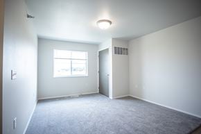 Rapid City apartment for rent - A spacious room with a window and carpeted floor.