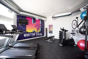 Sioux Falls apartment for rent - a gym with cardio equipment and a wall mural of what the floss looks like
