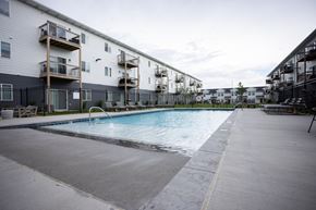 Sioux Falls apartment for rent - a pool is shown in front of an apartment building