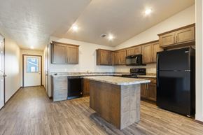 Harrisburg townhouse for rent - A kitchen with a black refrigerator and wooden cabinets.