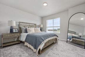 Sioux Falls townhouse for rent - A bedroom with a large bed and a mirror on the wall.