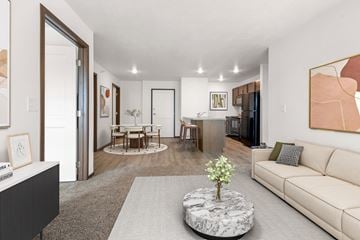 Sioux Falls apartment for rent - A living room with a white couch and a coffee table with a plant on it.