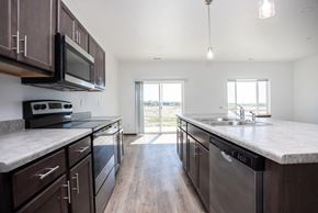 Sioux Falls apartment for rent - a large kitchen with stainless steel appliances and marble counter tops