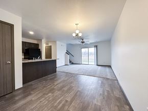 Sioux Falls townhouse for rent - A spacious living room with wood flooring and a ceiling fan.
