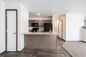 Sioux Falls townhouse for rent - A kitchen with a black stove top oven and white cabinets.