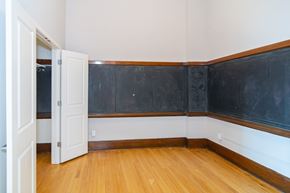 Sioux City apartment for rent - A room with a blackboard on the wall and a wooden floor.
