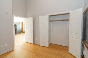 Sioux City apartment for rent - A room with white walls and wooden floors, with a doorway leading to another room.