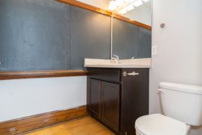 Sioux City apartment for rent - A bathroom with a toilet, sink, and wooden cabinet.