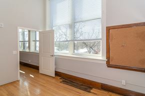 Sioux City apartment for rent - A room with a white door, a window with blinds, and a corkboard on the wall.