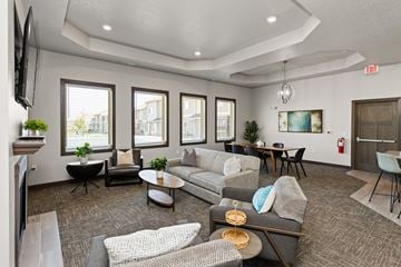 Waukee townhouse for rent - A living room with grey and white furniture and a fireplace.