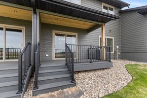Brandon townhouse for rent - A modern house with a grey exterior and a black metal railing on the stairs.