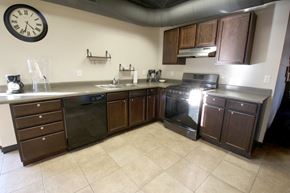 Sioux Falls apartment for rent - a kitchen with a clock on the wall and wooden cabinets