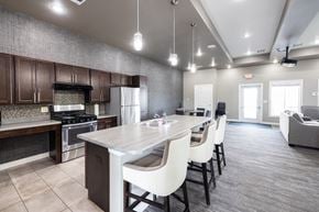 Sioux Falls townhouse for rent - A modern kitchen with a large island and white chairs.