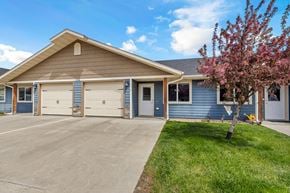 Brandon townhouse for rent - A house with a blue exterior and a brown roof with a tree in front.