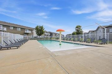 Sioux Falls townhouse for rent - A swimming pool with a green pole and a red umbrella in the middle of it.