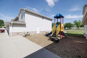 Mitchell townhouse for rent - A playground with a slide and a white house in the background.