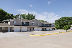 Mitchell townhouse for rent - A parking lot in front of a building with a yellow line painted on the ground.