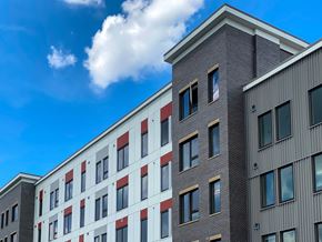 Jersey City apartment for rent - a large brick building with windows against a blue sky