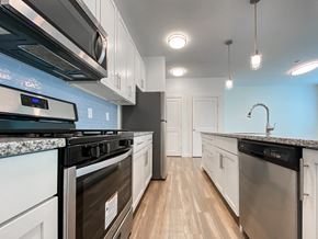 Jersey City apartment for rent - an empty kitchen with white cabinets and stainless steel appliances