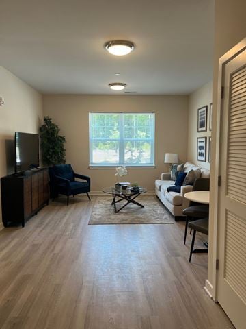 South Brunswick apartment for rent - A living room with a black television and a blue chair.