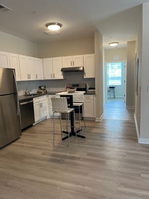South Brunswick apartment for rent - A kitchen with a refrigerator, sink, and a dining table with two chairs.