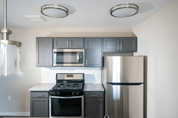Newark apartment for rent - a kitchen with stainless steel appliances and gray cabinets
